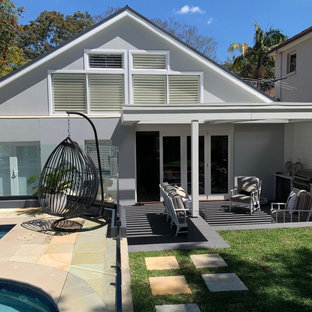 Example of a mid-sized cottage chic backyard stone patio kitchen design in Sydney with a pergola