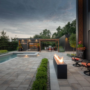 Ispirazione per un grande patio o portico minimalista dietro casa con un caminetto, pavimentazioni in pietra naturale e una pergola