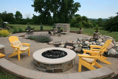 Imagen de patio tradicional grande sin cubierta en patio trasero con brasero y adoquines de piedra natural