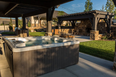 Huge arts and crafts backyard concrete patio kitchen photo in Salt Lake City with a gazebo