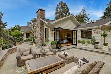 Exemple d'une terrasse arrière chic de taille moyenne avec des pavés en pierre naturelle et aucune couverture.