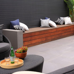 Ispirazione per un patio o portico moderno di medie dimensioni e nel cortile laterale con piastrelle e una pergola