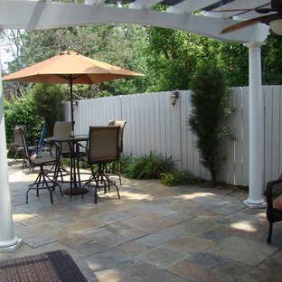 Esempio di un patio o portico tradizionale di medie dimensioni e dietro casa con piastrelle e una pergola