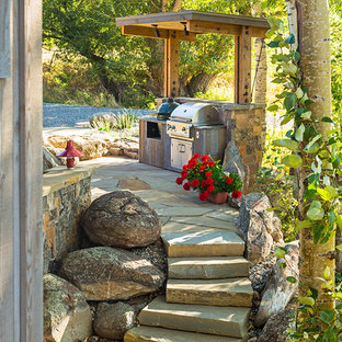 Idee per un patio o portico rustico con pavimentazioni in pietra naturale