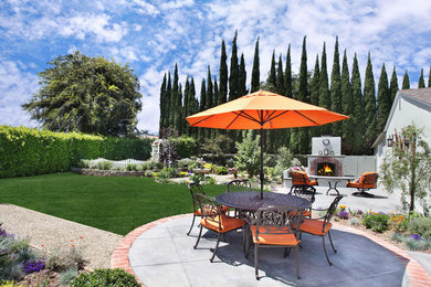 Inspiration for a large timeless backyard concrete patio remodel in Orange County with a fire pit and no cover