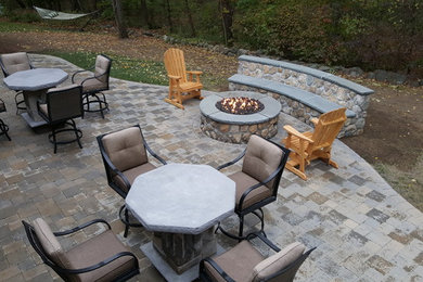 Elegant backyard patio photo in Boston with a fire pit and no cover