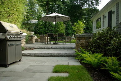 Diseño de patio clásico renovado en patio trasero con adoquines de piedra natural