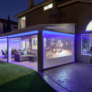 Foto di un patio o portico mediterraneo di medie dimensioni e dietro casa con lastre di cemento e un parasole