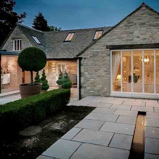 Esempio di un ampio patio o portico country in cortile con fontane, pavimentazioni in pietra naturale e nessuna copertura