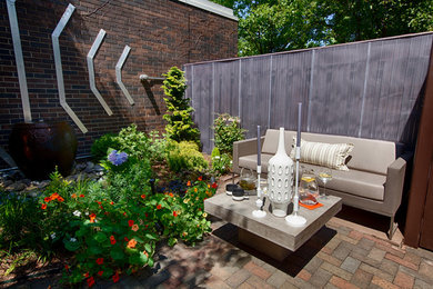Modelo de patio actual de tamaño medio sin cubierta en patio lateral con fuente y adoquines de ladrillo