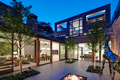 Patio - large contemporary courtyard brick patio idea in Chicago with no cover