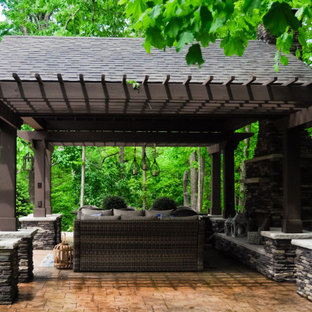 Idee per un grande patio o portico minimal dietro casa con un caminetto, pavimentazioni in cemento e un gazebo o capanno