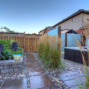Esempio di un grande patio o portico tropicale dietro casa con ghiaia e una pergola