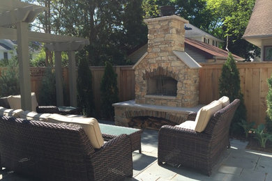 Large elegant backyard patio photo in Other with a fire pit and a pergola