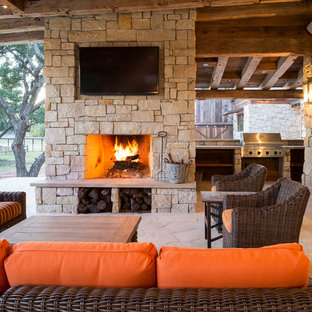 Foto di un patio o portico rustico con un focolare e un tetto a sbalzo