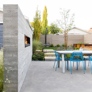 Esempio di un patio o portico design nel cortile laterale con un caminetto, lastre di cemento e nessuna copertura