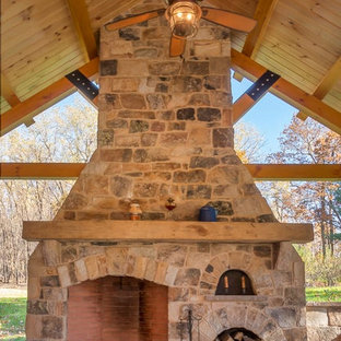 Idee per un patio o portico stile rurale dietro casa con un caminetto e un gazebo o capanno