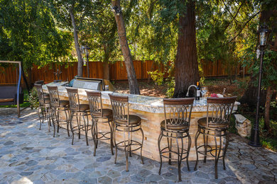 サンフランシスコにある広いトランジショナルスタイルのおしゃれな裏庭のテラス (アウトドアキッチン、天然石敷き、日よけなし) の写真
