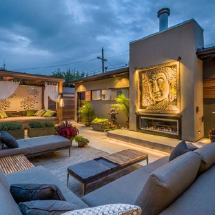 Idee per un patio o portico etnico di medie dimensioni e dietro casa con un caminetto
