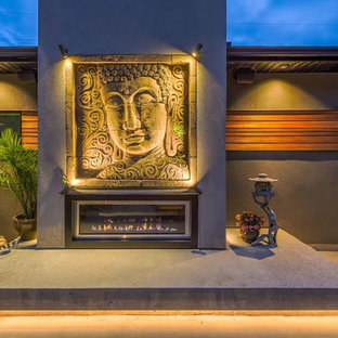 Immagine di un patio o portico etnico di medie dimensioni e dietro casa con un caminetto