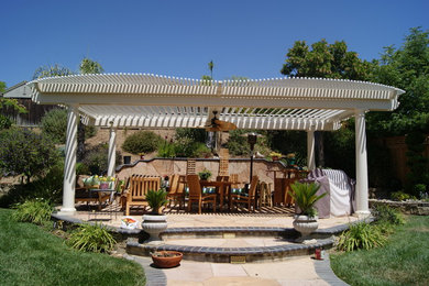 Foto de patio tradicional de tamaño medio en patio trasero con brasero, adoquines de piedra natural y pérgola