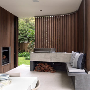 Foto di un patio o portico minimal con un focolare