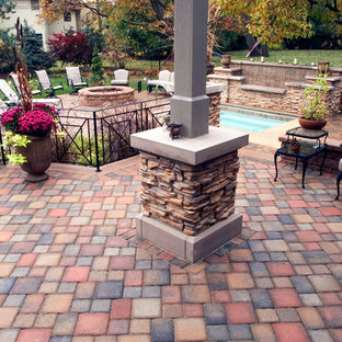 Immagine di un patio o portico eclettico di medie dimensioni e dietro casa con fontane, pavimentazioni in cemento e una pergola