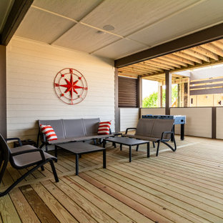 Esempio di un ampio patio o portico stile marinaro dietro casa con pedane e un tetto a sbalzo