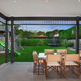 Foto di un piccolo patio o portico costiero dietro casa con pavimentazioni in cemento