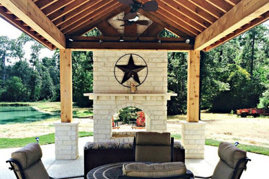 Example of a large country backyard concrete patio design in Houston with a fire pit and a gazebo