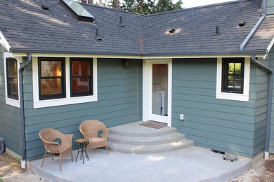 Ejemplo de patio de estilo americano de tamaño medio sin cubierta en patio trasero con losas de hormigón