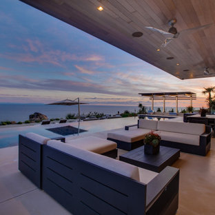Esempio di un ampio patio o portico moderno dietro casa con un focolare e una pergola