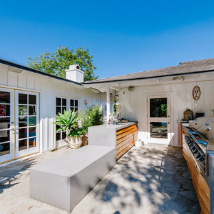 Immagine di un ampio patio o portico boho chic dietro casa con pavimentazioni in pietra naturale e nessuna copertura