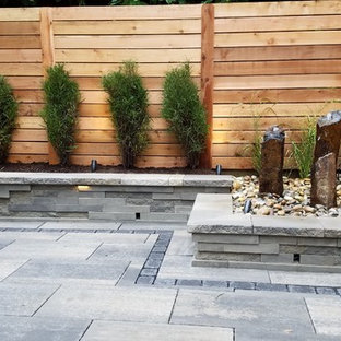 Example of a mid-sized minimalist backyard tile patio design in Philadelphia with no cover