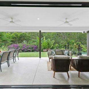 Foto di un grande patio o portico etnico dietro casa con cemento stampato e un tetto a sbalzo