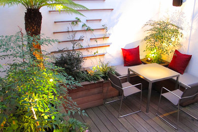 Пример оригинального дизайна: маленький двор на внутреннем дворе в современном стиле с растениями в контейнерах и настилом для на участке и в саду