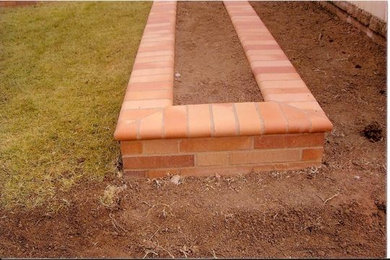 Example of a backyard brick patio design in Los Angeles with no cover