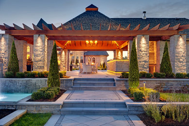 Immagine di un grande patio o portico classico dietro casa con lastre di cemento e una pergola