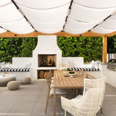 Example of a large trendy backyard concrete paver patio kitchen design in Phoenix with an awning