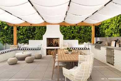 Immagine di un grande patio o portico design dietro casa con pavimentazioni in cemento e un parasole