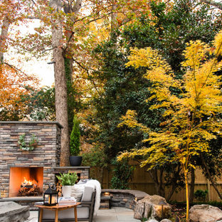 Esempio di un patio o portico minimalista di medie dimensioni e dietro casa con un caminetto e pavimentazioni in pietra naturale