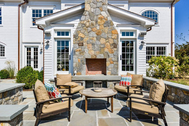 Inspiration for a timeless patio remodel in New York with a fireplace and no cover