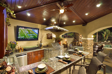 Example of a large tuscan backyard concrete patio kitchen design in Orange County with a gazebo