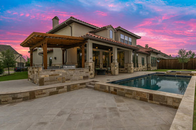 Large tuscan backyard concrete paver patio kitchen photo in Dallas with a roof extension