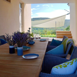 Ispirazione per un grande patio o portico mediterraneo in cortile con pedane e un tetto a sbalzo