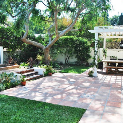 Inspiration for a mediterranean backyard tile patio fountain remodel in Los Angeles with a pergola