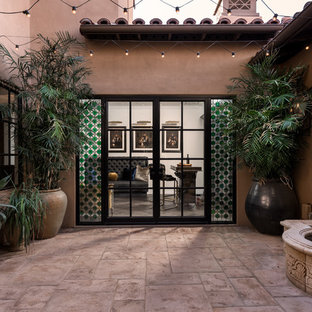 Foto di un ampio patio o portico mediterraneo in cortile con fontane, pavimentazioni in pietra naturale e nessuna copertura