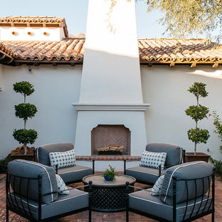 Ispirazione per un grande patio o portico mediterraneo dietro casa con un focolare, pavimentazioni in mattoni e nessuna copertura