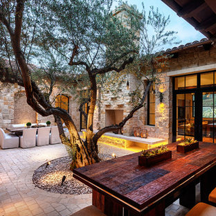 Immagine di un patio o portico mediterraneo in cortile con un focolare