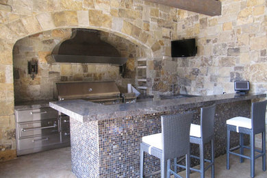 Diseño de patio mediterráneo de tamaño medio en patio trasero y anexo de casas con cocina exterior y adoquines de piedra natural